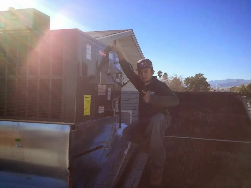 HVAC technician performing Air Duct Cleaning on a rooftop unit in Rocky Hill